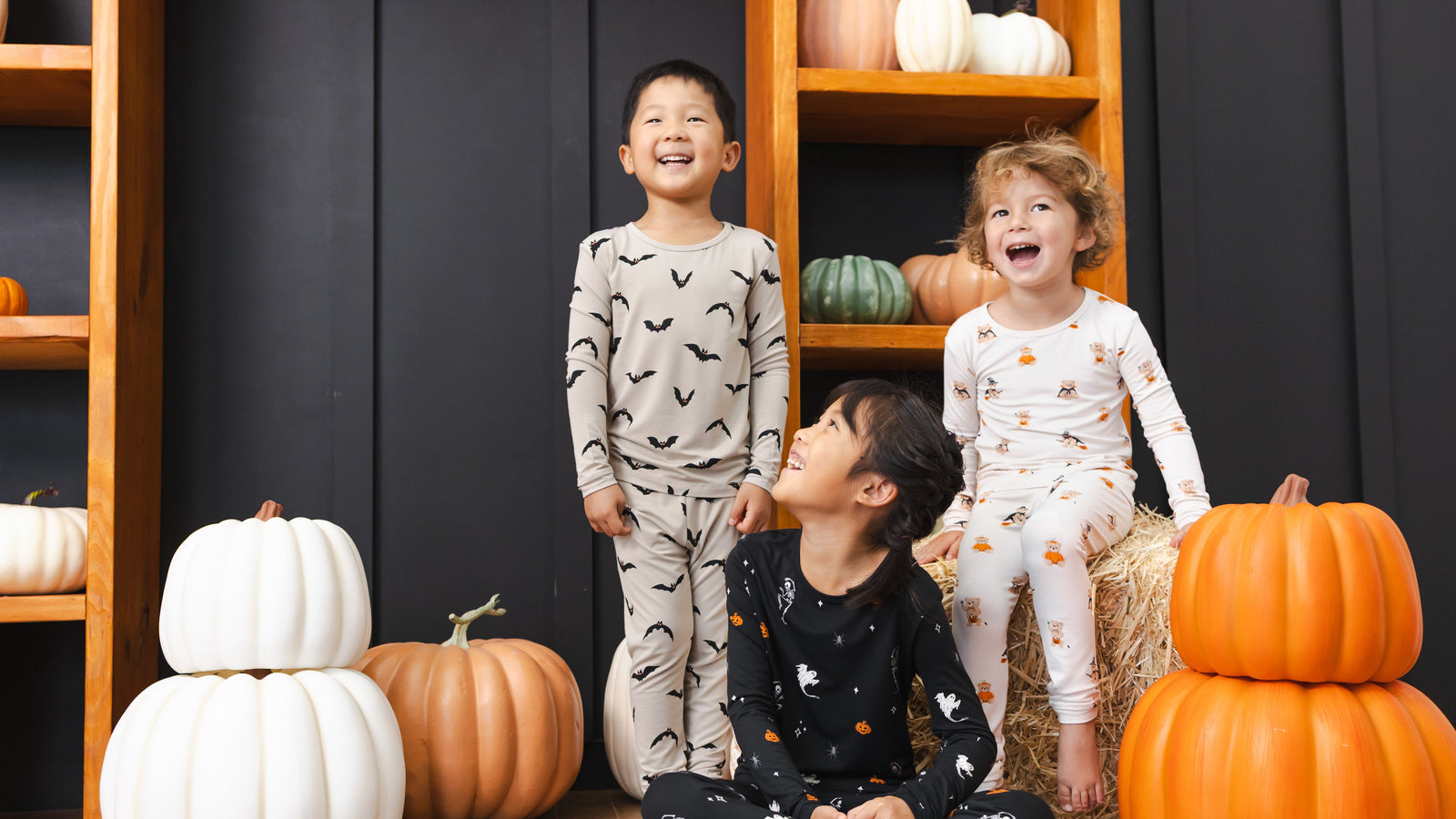 Three children in matching Halloween pyjamas