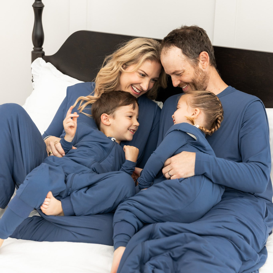 Family in bed wearing matching sleep bag walkers