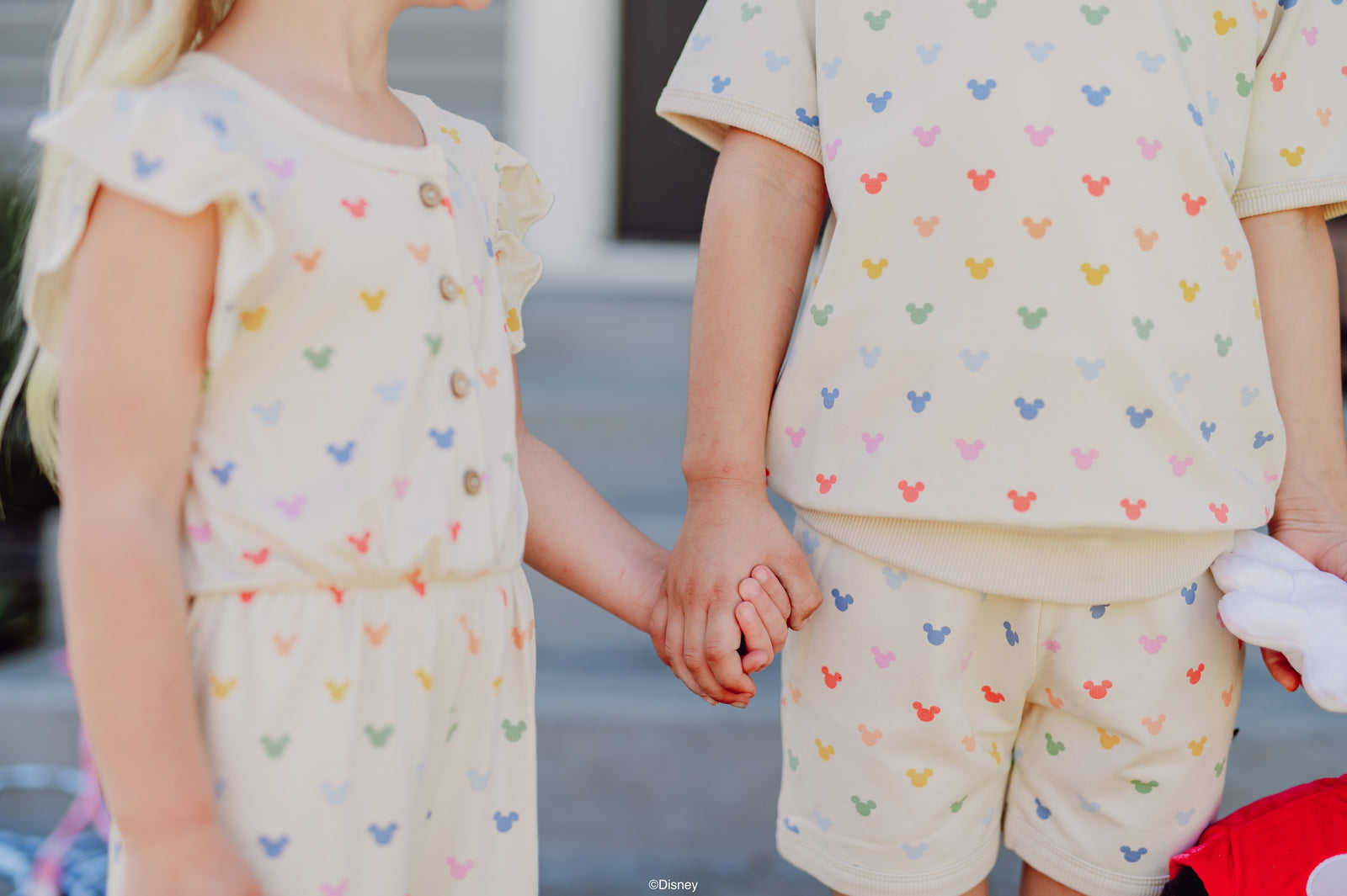 Child in a pastel Mickey print flutter sleeve romper and jogger set